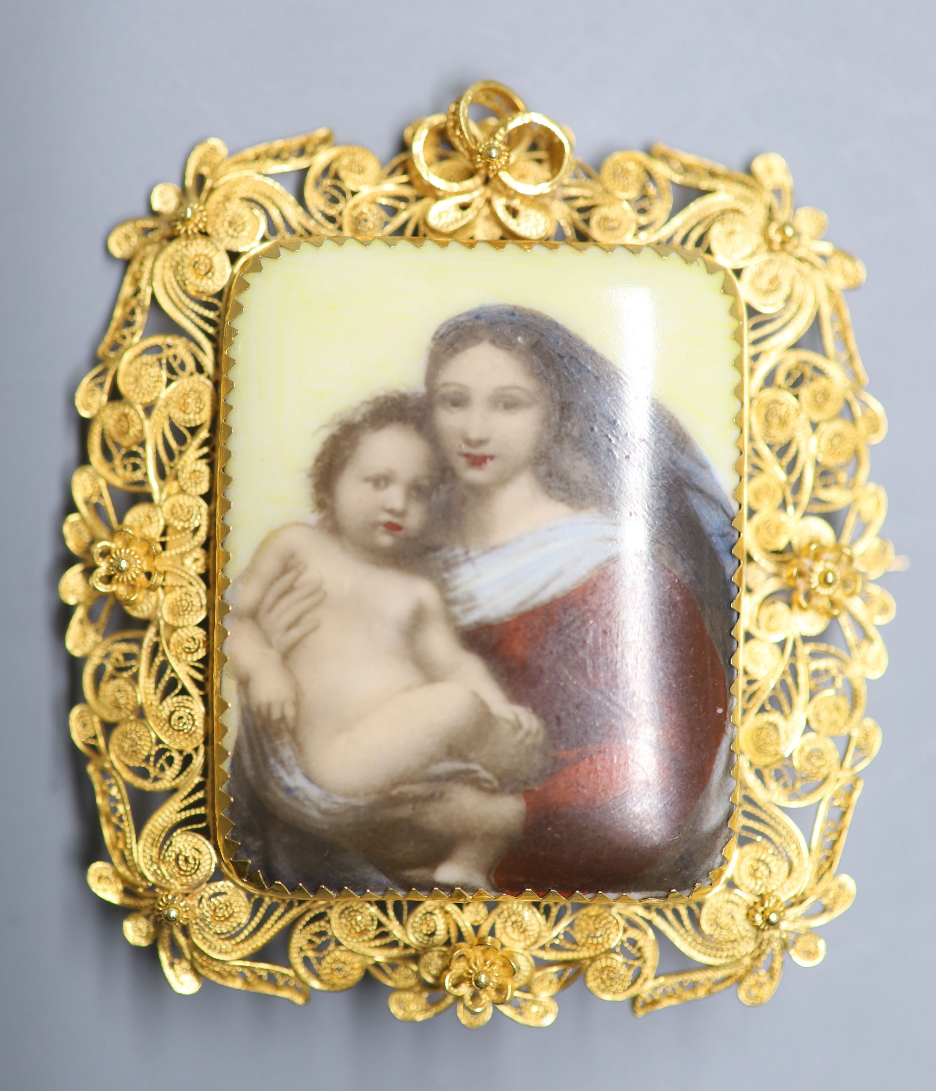 A 20th century filligree yellow metal mounted porcelain plaque pendant brooch, decorated with Madonna & Child, 60mm,